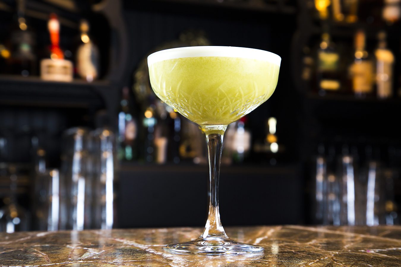 A coupe with a lime twist on the bar.